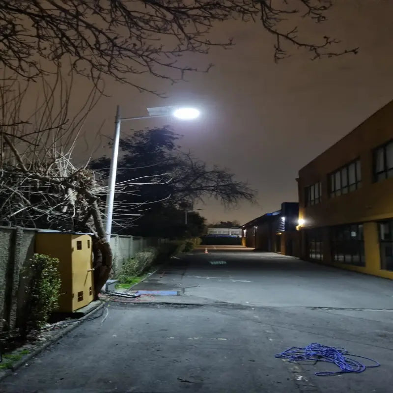 Foco solar LED 1500W iluminando un pasillo industrial de noche en Chile