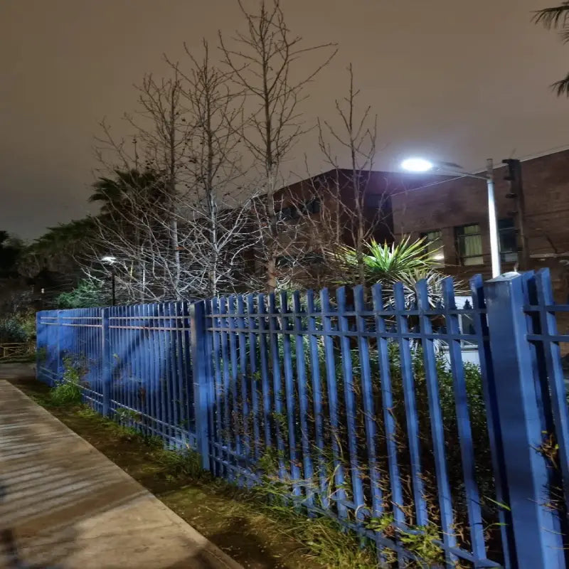 Foco solar LED 1500W instalado en poste iluminando el perímetro de un condominio de noche