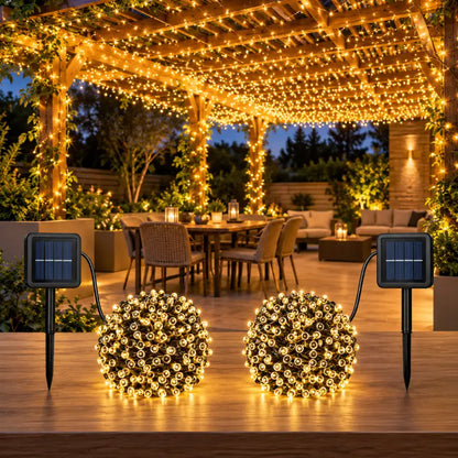 Luces solares cálidas de la guirnalda de 24 metros decorando un patio exterior de noche